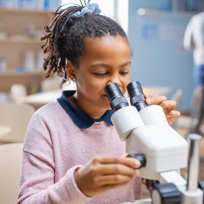 Photo of child looking through microscope